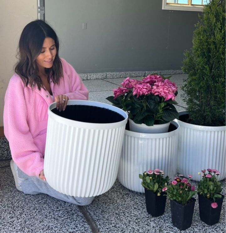 Christine Andrew planting flowers in her new white planter pots.