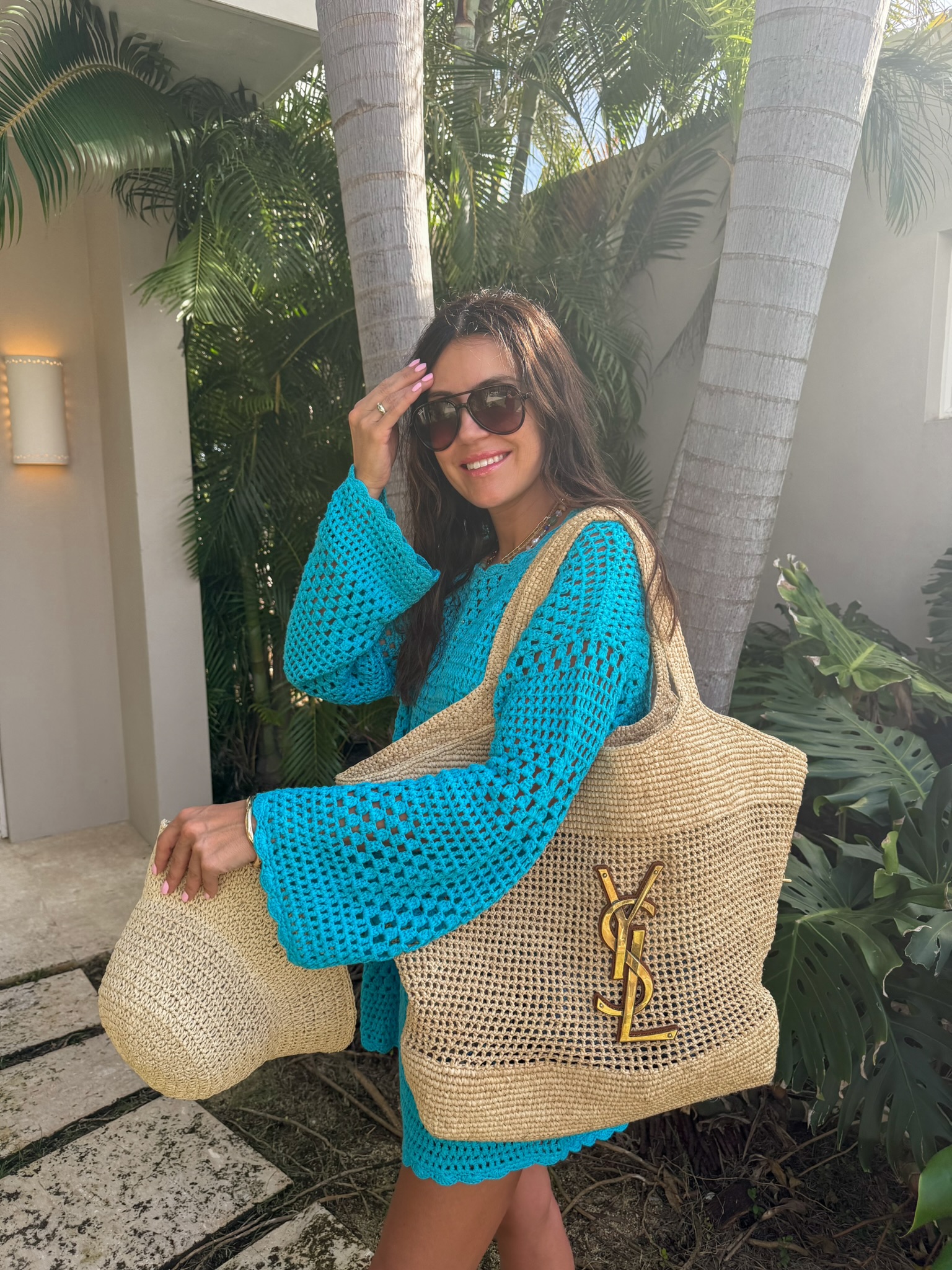 Christine Andrew in a blue crochet swimsuit coverup on beach vacation
