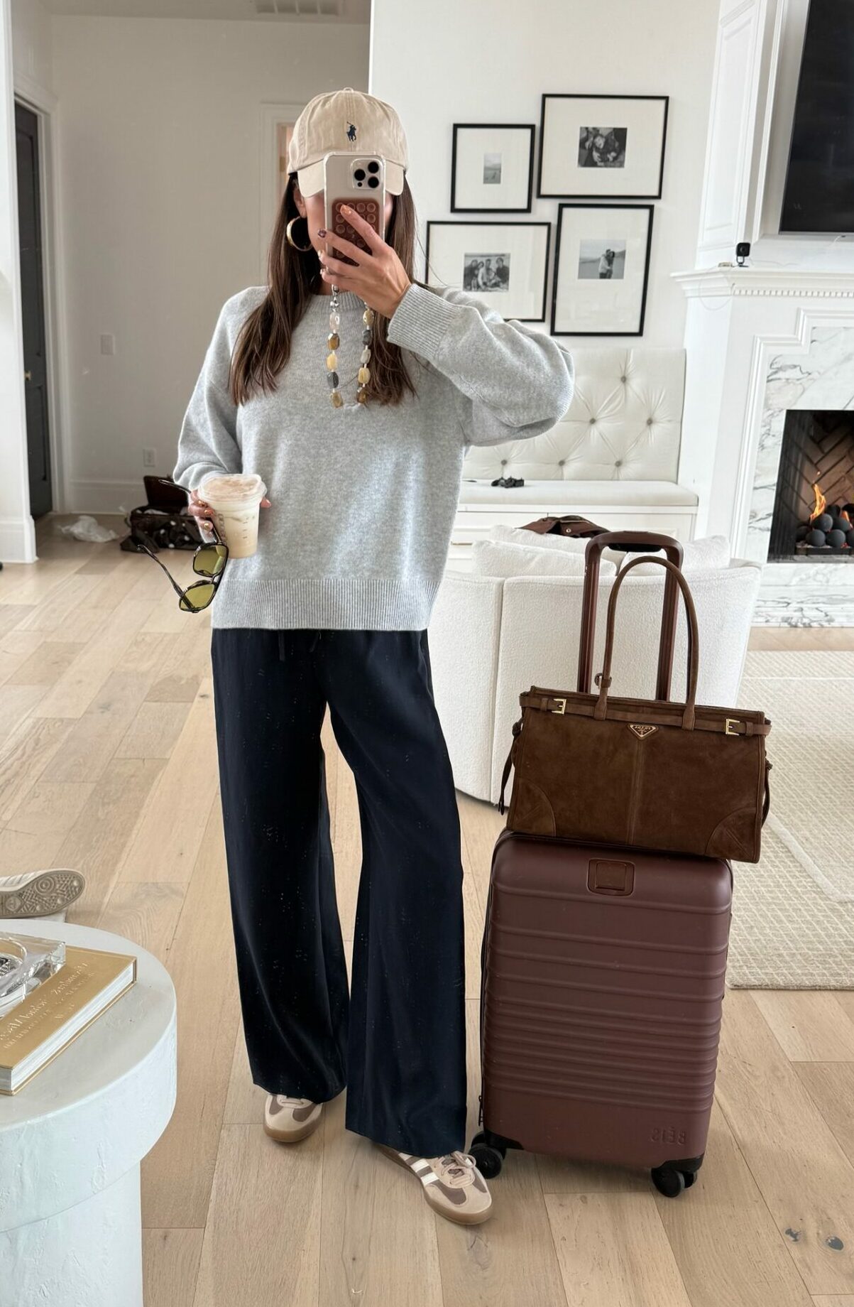Christine Andrew in a fall travel outfit from aritzia with beis suitcase